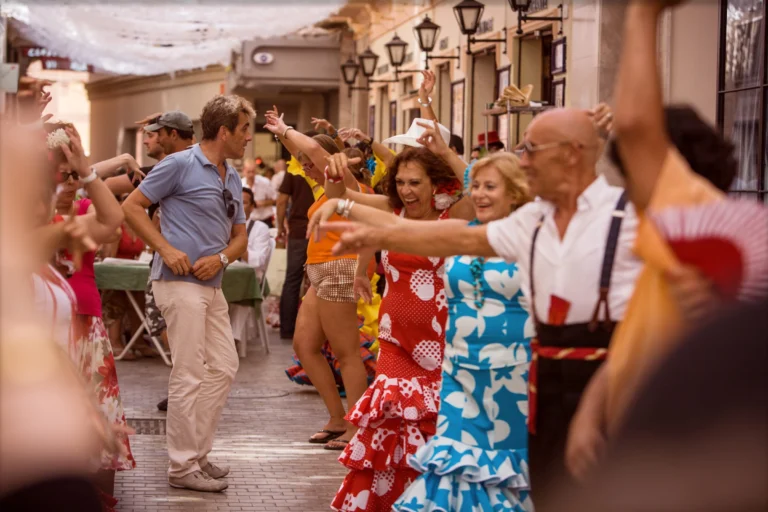 A group of travelers enjoying a lively street festival or dance in a Mediterranean town.