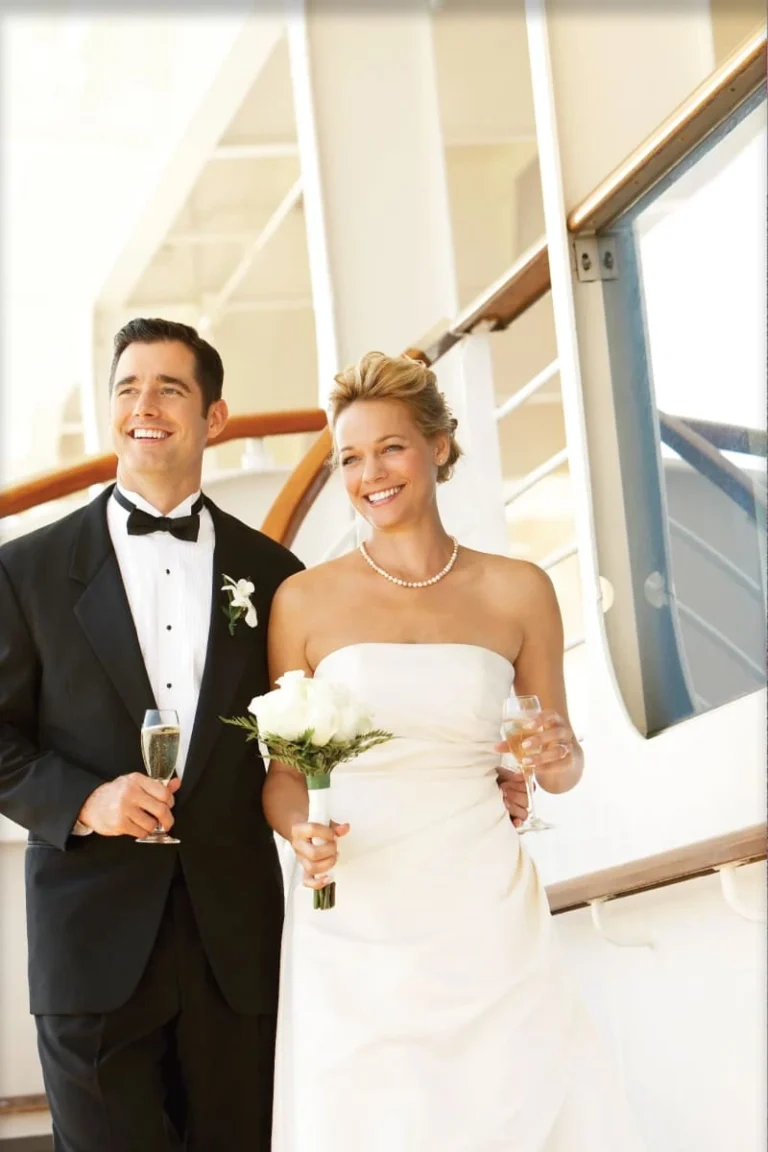 A bride and groom in wedding attire standing on a Princess Cruises ship deck.