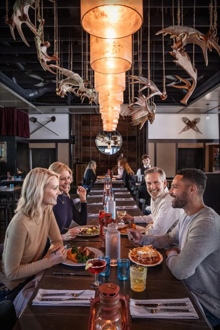 A beautifully lit, upscale dining room filled with guests enjoying a fine meal.