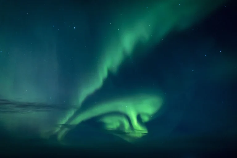 Norway cruise destination featuring northern lights above dramatic fjord landscapes.
