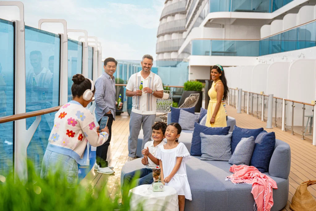 Guests relaxing on the outdoor deck of a Princess Cruises ship while enjoying ocean views and onboard activities.