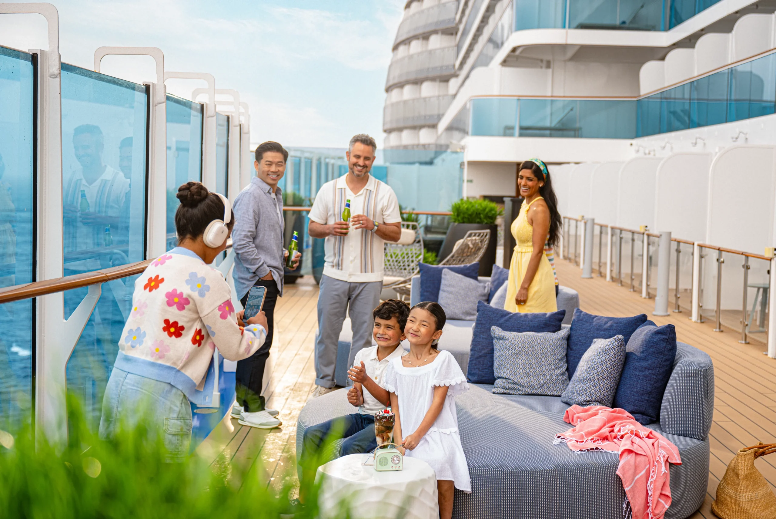 Guests relaxing on the outdoor deck of a Princess Cruises ship while enjoying ocean views and onboard activities.