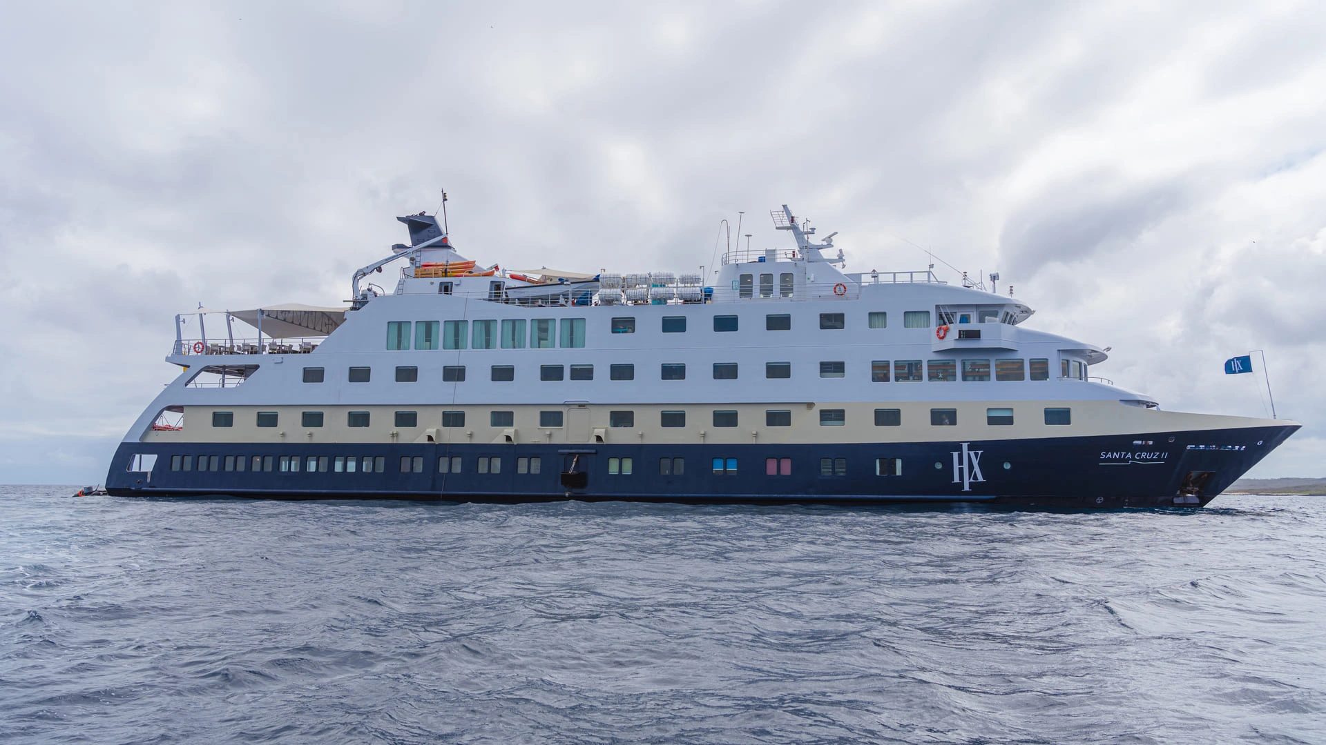 HX Expeditions' Santa Cruz II expedition ship sailing across open waters during an expedition voyage.