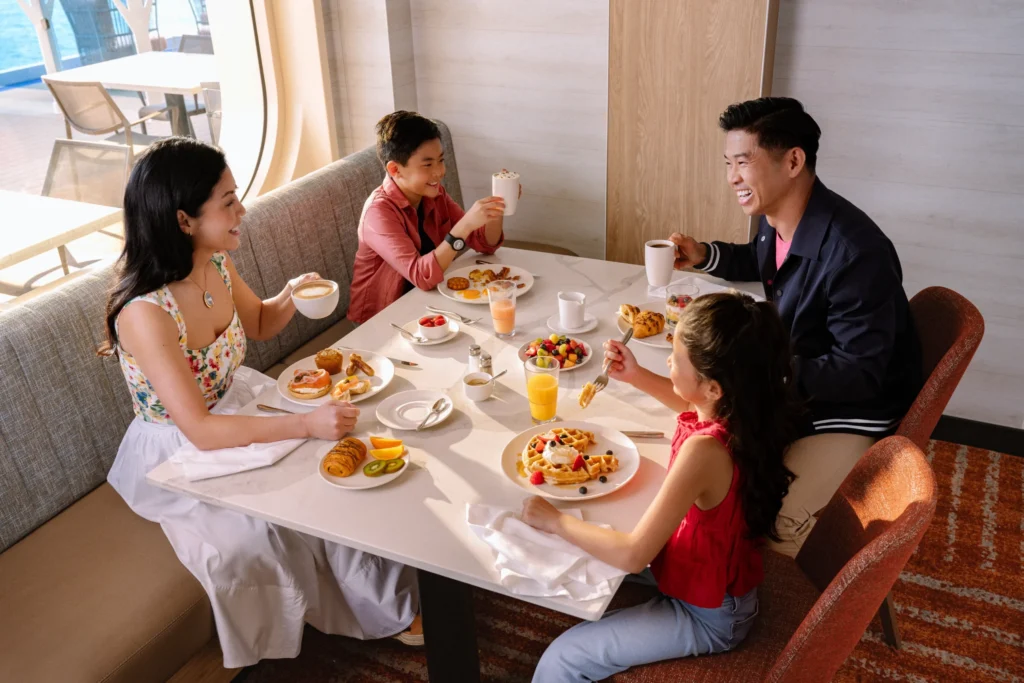 Family enjoying dinner together on a mainstream cruise ship, showcasing the onboard dining experience in the Mainstream Cruise vs Expedition Cruise comparison.