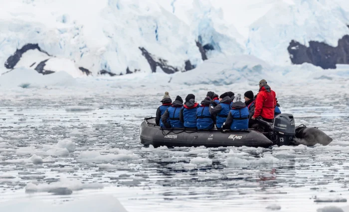 A group of people enjoying zodiac cruising in Antarctica by Aurora Expeditions.