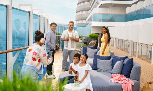 Guests relaxing on the outdoor deck of a Princess Cruises ship while enjoying ocean views and onboard activities.